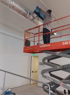 technician cleaning ducts in large commercial building